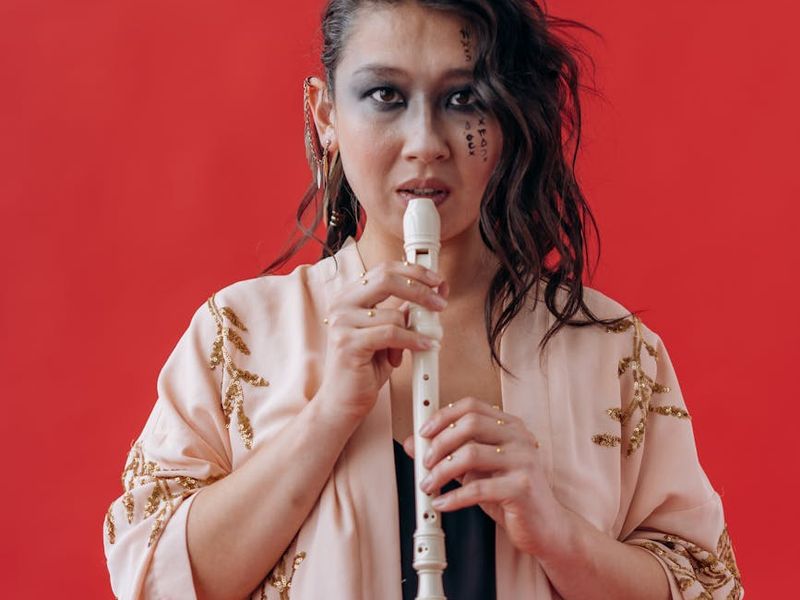 Woman holding a challenging balance yoga pose with focused expression.